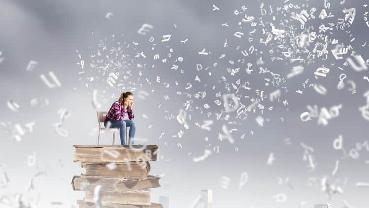 Frau sitzt auf Büchern