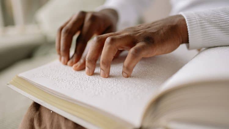 Hände ertasten Blindenschrift