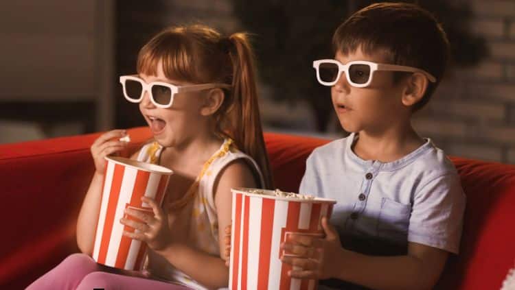 Kinder essen Popcorn und schauen Fernsehen