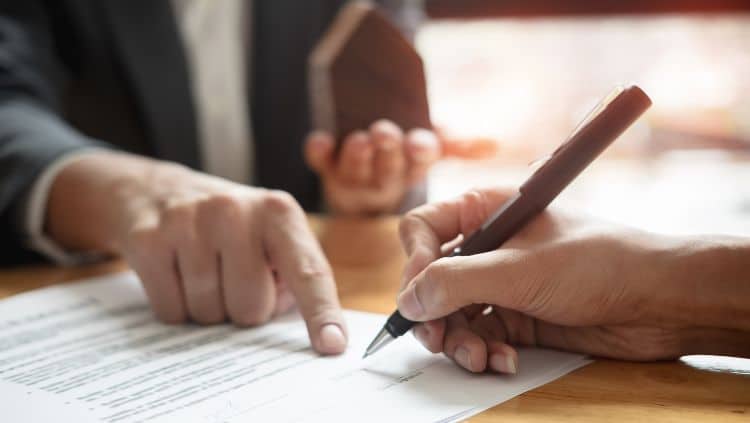 Person zeigt auf Papier und andere Person hält Stift in der Hand