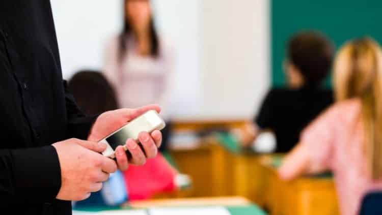 Lehrer mit Handy in Hand