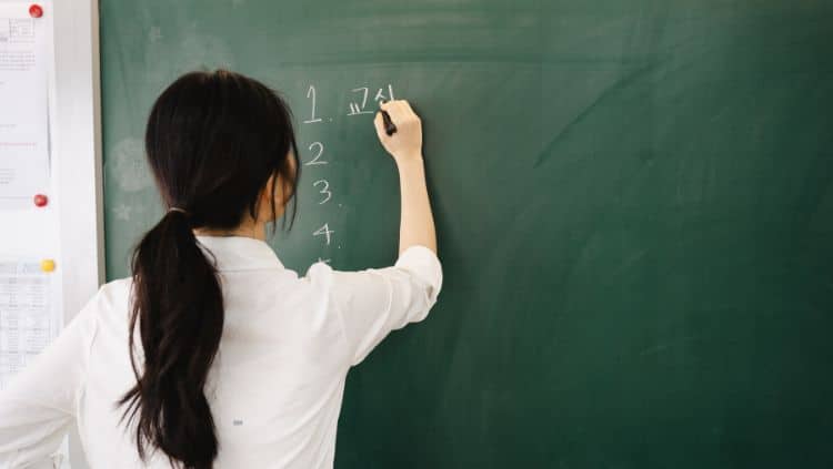 Lehrerin schreibt an Tafel